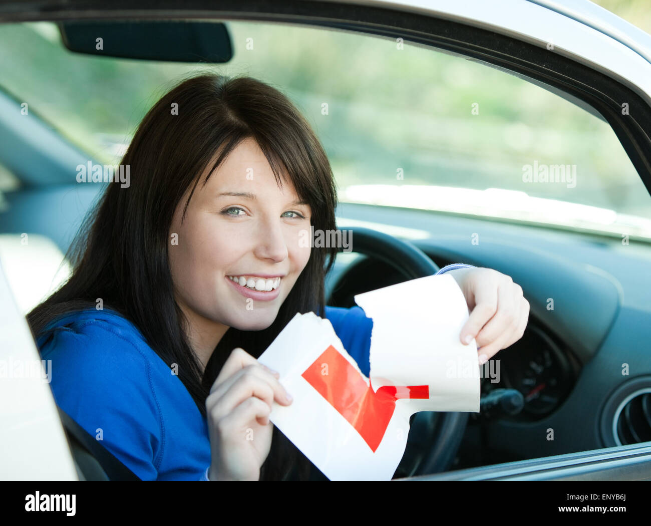 Affascinante brunette teen ragazza seduta nella sua auto la lacerazione di una L-segno Foto Stock