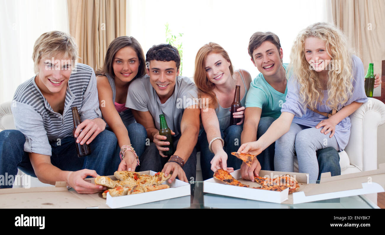 Gli amici di mangiare la pizza a casa Foto Stock