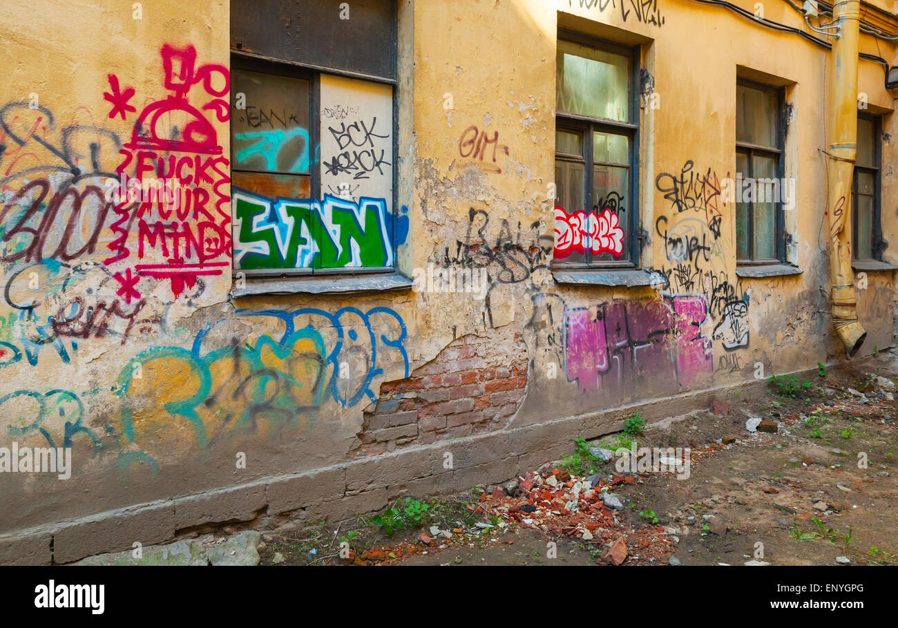 San Pietroburgo, Russia - 6 Maggio 2015: abbandonato urban cortile con abstract i graffiti sulla parete danneggiata con finestra. Vasilievs Foto Stock