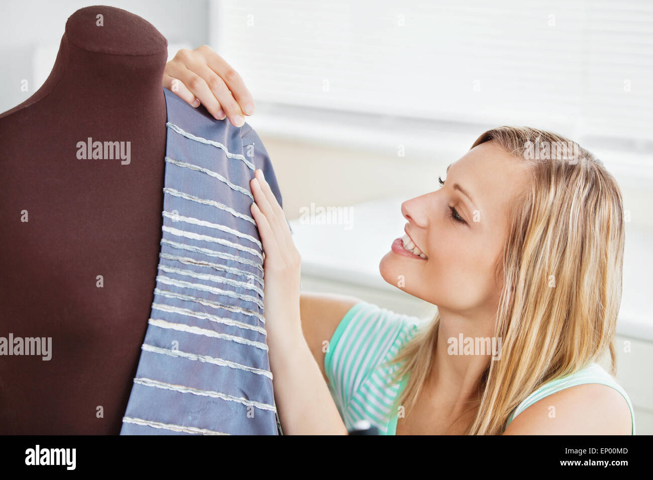 Incandescente donna abiti da cucire in cucina Foto Stock