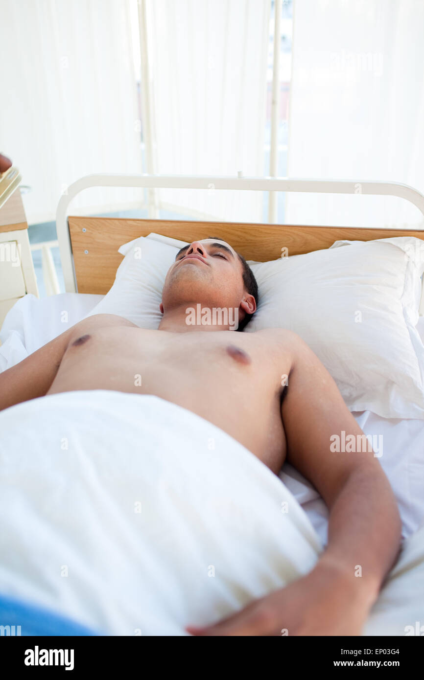 Giovane paziente sdraiato sul letto di un ospedale Foto Stock