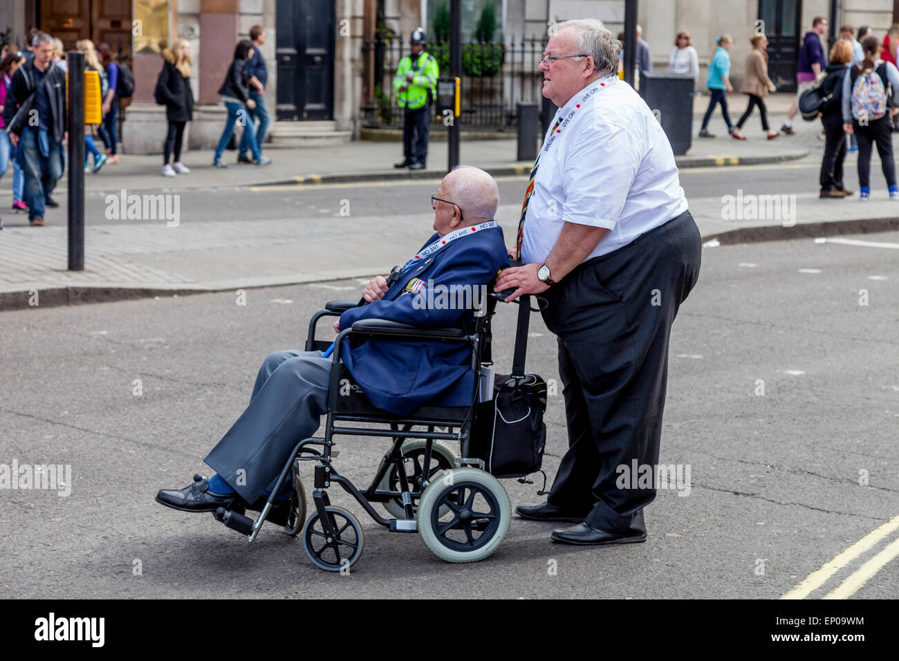 Un anziano veterano di guerra in una sedia a rotelle arriva a Trafalgar Square per il settantesimo anniversario del giorno ve celebrazioni, London, Regno Unito Foto Stock