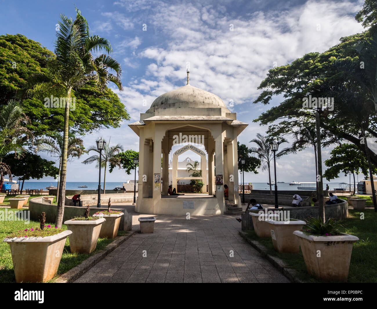 Persone in appoggio Forodani park (Forodani gardens) nel lungomare di Stone Town, Zanzibar, Africa orientale. Orientamento orizzontale. Foto Stock