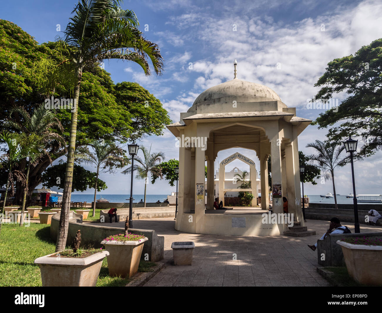 Persone in appoggio Forodani park (Forodani gardens) nel lungomare di Stone Town, Zanzibar, Africa orientale. Orientamento orizzontale. Foto Stock
