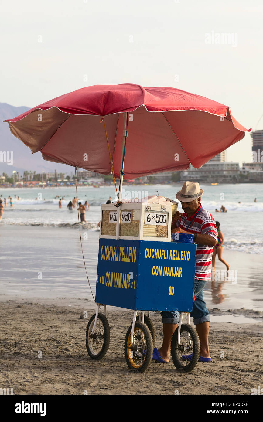 Uomo in piedi al riempimento del carrello il tradizionale dolce cileno chiamato Cuchufli Cavancha sulla spiaggia di Iquique, Cile Foto Stock