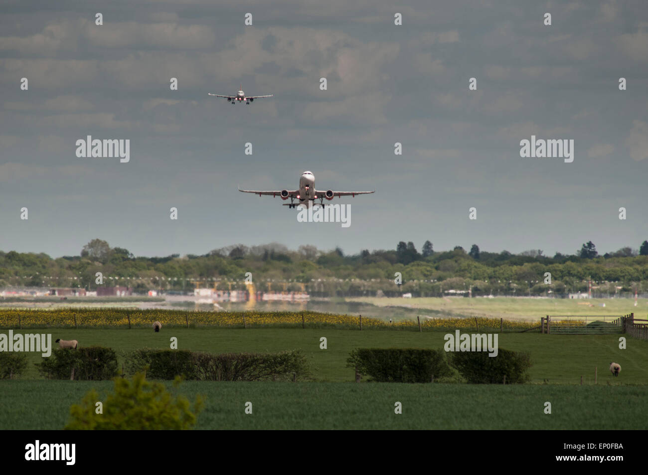 Dall'Aeroporto Gatwick di Londra, Surrey, Regno Unito. Il 12 maggio 2015. Meteo: aerei di atterraggio e di decollo oltre la scena rurale attorno a Gatwick occupato . Credito: David Burr/Alamy Live News Foto Stock