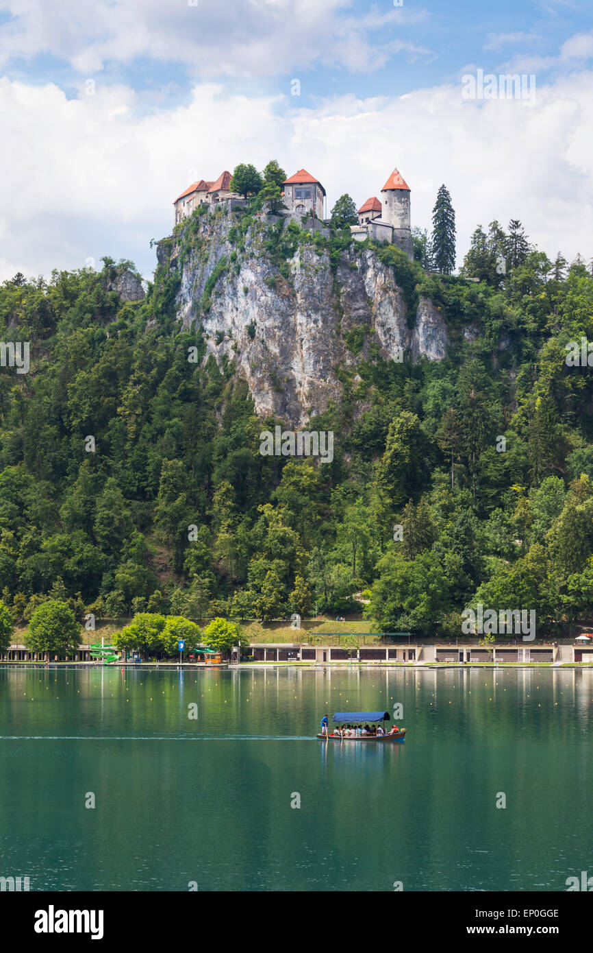 Il lago di Bled e Alta Carniola, Slovenia. Il castello di Bled si vede attraverso il lago. Turisti che si godono la nautica escursione. Foto Stock