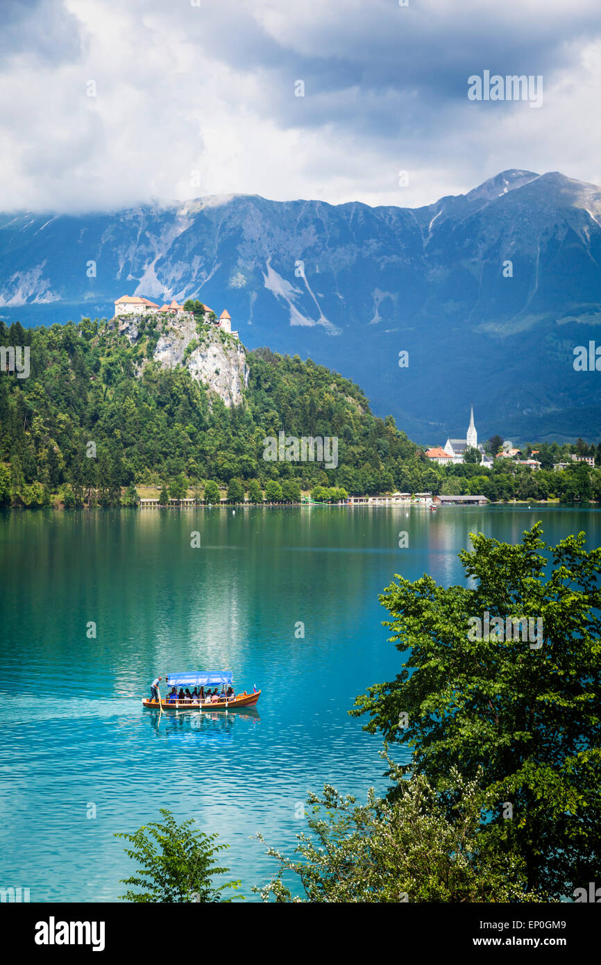 Il lago di Bled e Alta Carniola, Slovenia. Il castello di Bled si vede attraverso il lago. La città di Bled in background. Foto Stock