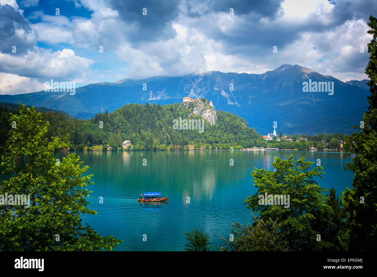Il lago di Bled e Alta Carniola, Slovenia. Il castello di Bled si vede attraverso il lago. La città di Bled in background. Foto Stock