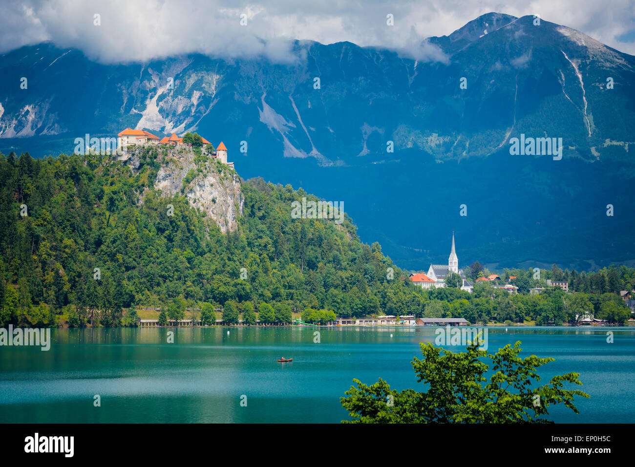 Il lago di Bled e Alta Carniola, Slovenia. Il castello di Bled si vede attraverso il lago. La città di Bled in background. Foto Stock