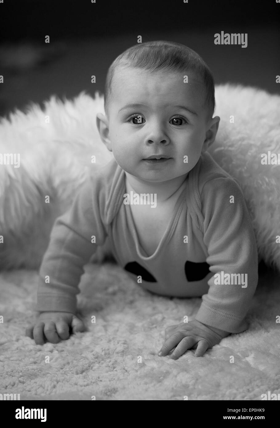 Baby boy in bianco e nero alla ricerca di curiosi in coperta Foto Stock