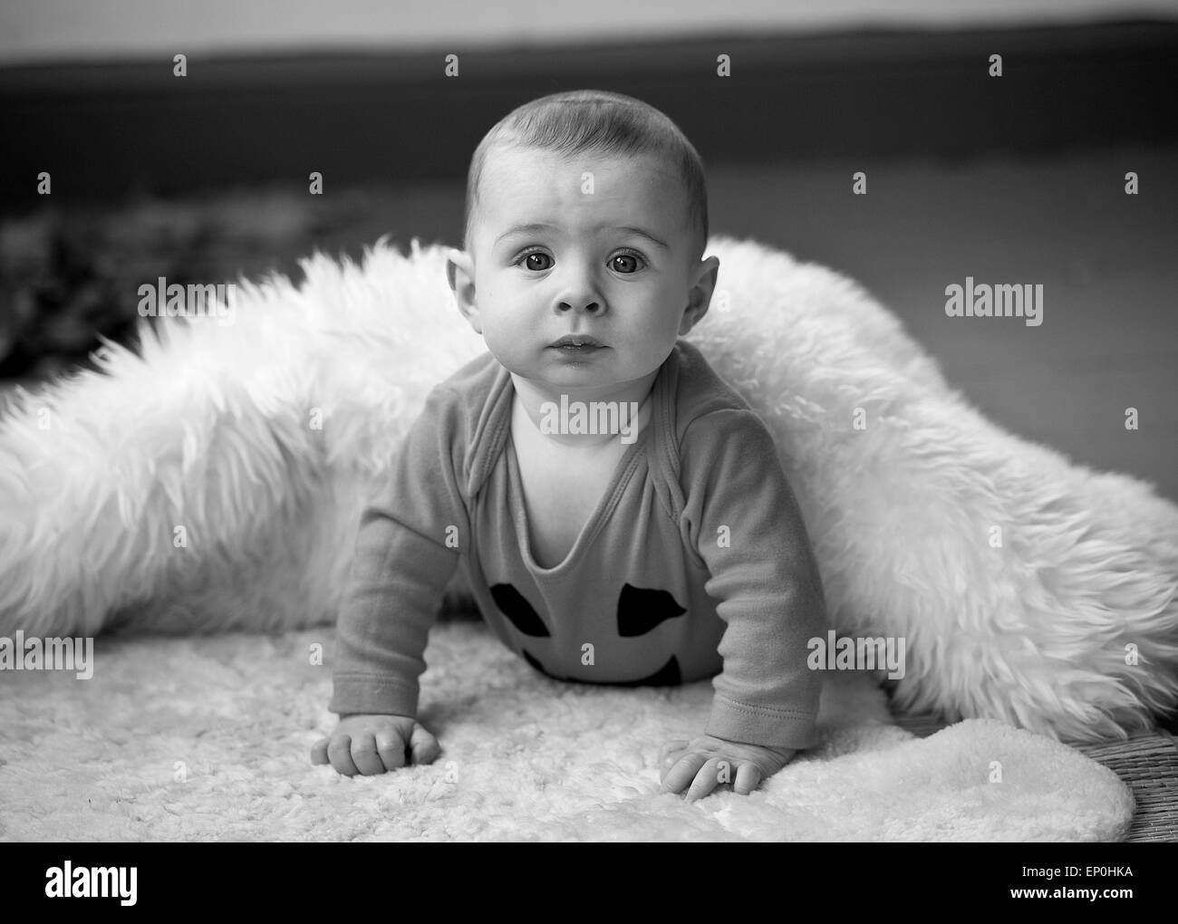 Baby boy in bianco e nero alla ricerca di curiosi in coperta Foto Stock