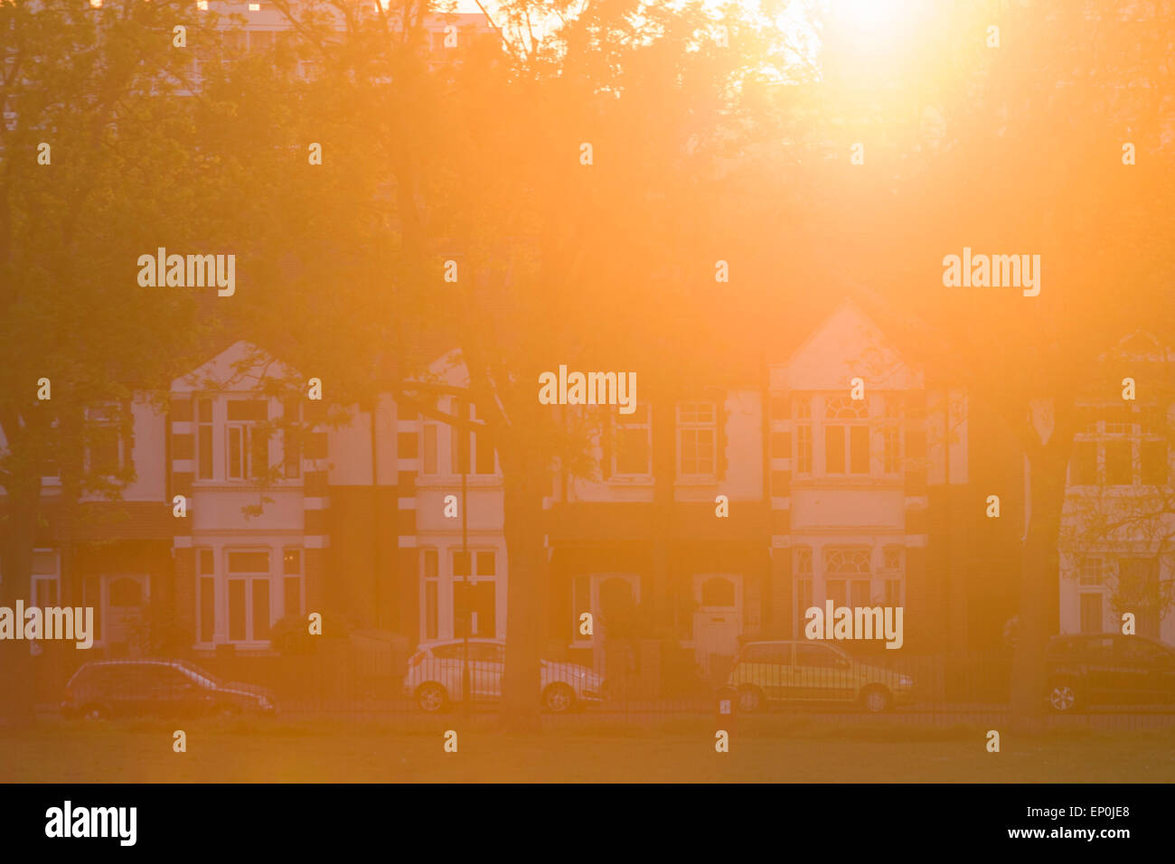 Caldo, orange il riflesso della luce del sole da un sole di setting e periodo edoardiano case in South London borough di Lambeth. Foto Stock