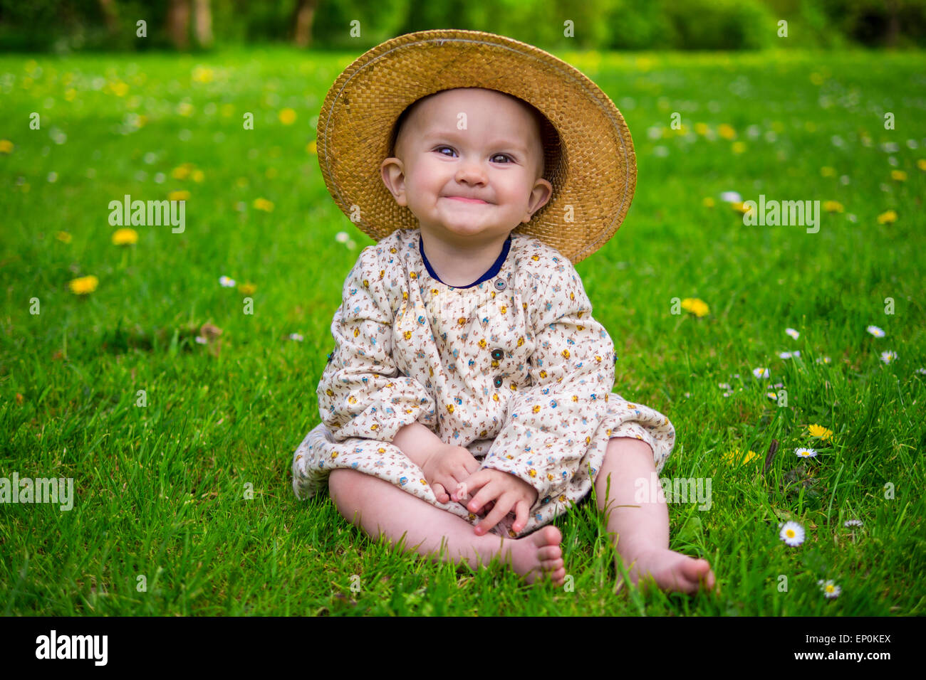 Adorabile bambina seduti in un parco e sorridente Foto Stock
