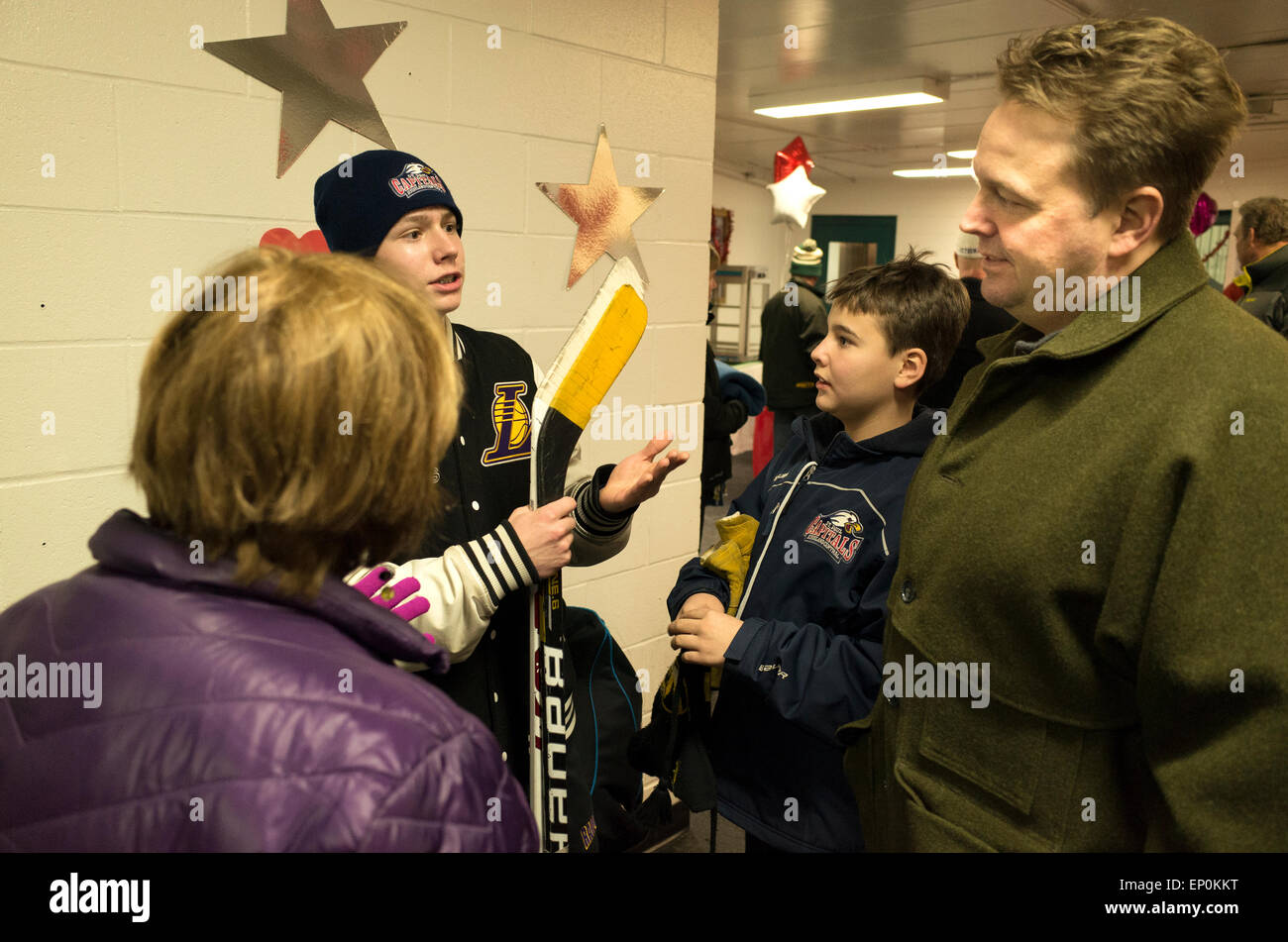 Teen boy esprimere le sottigliezze di hockey su ghiaccio per la sua famiglia. St Paul Minnesota MN USA Foto Stock