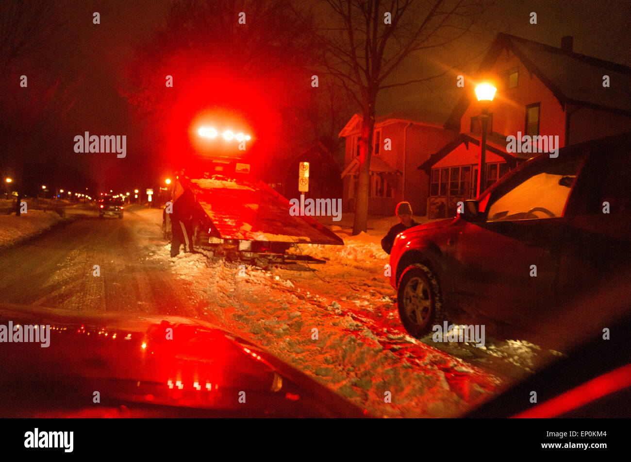 Trainare il carrello pronto a prelevare illegalmente auto parcheggiate durante la notte dopo nevicate invernali. St Paul Minnesota MN USA Foto Stock
