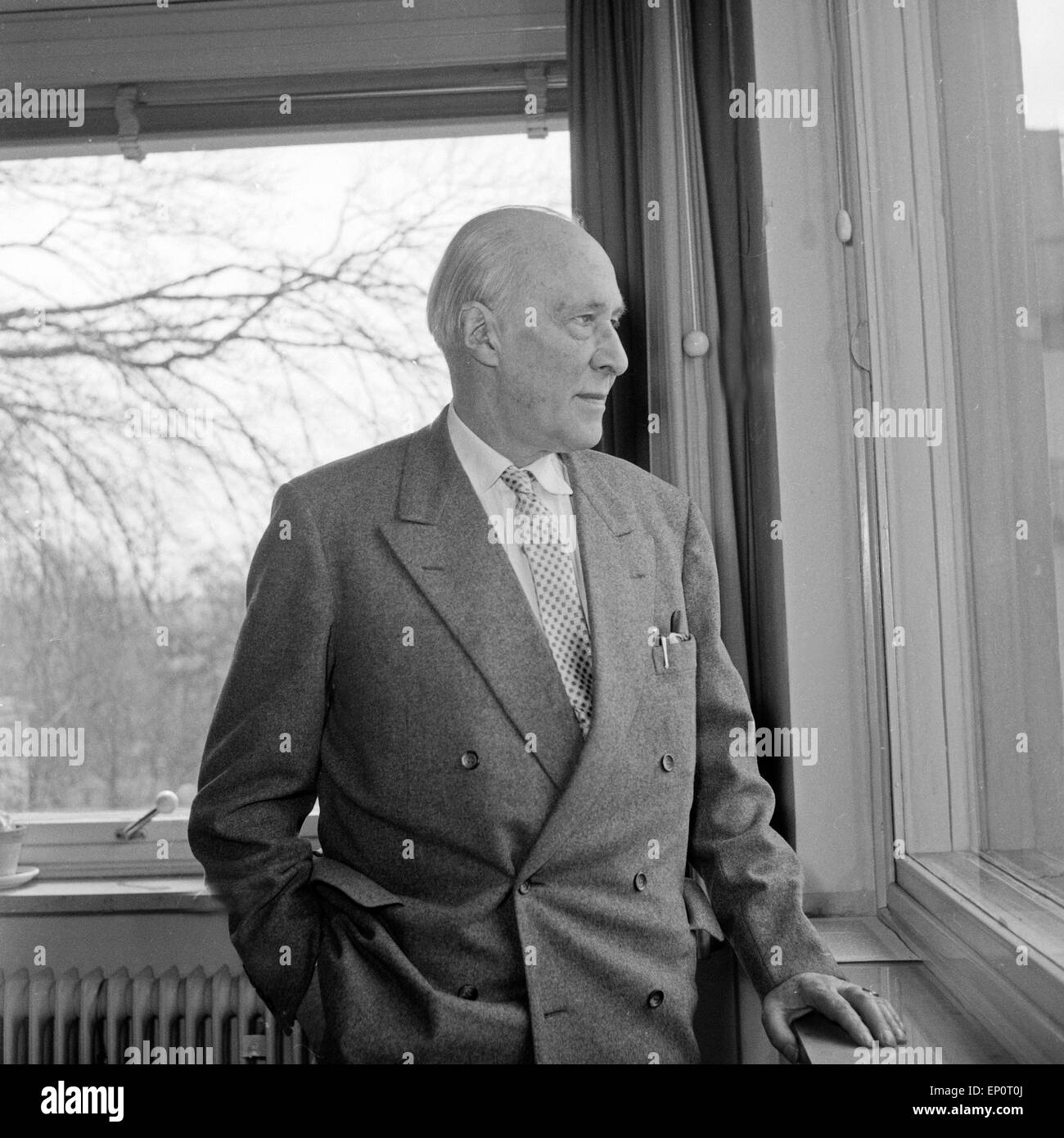 Der Schriftsteller, Erzähler und Drehbuchautor dott. Walther von Hollander am Fenster in seinem Büro, Amburgo 1956. Autore tedesco, Foto Stock