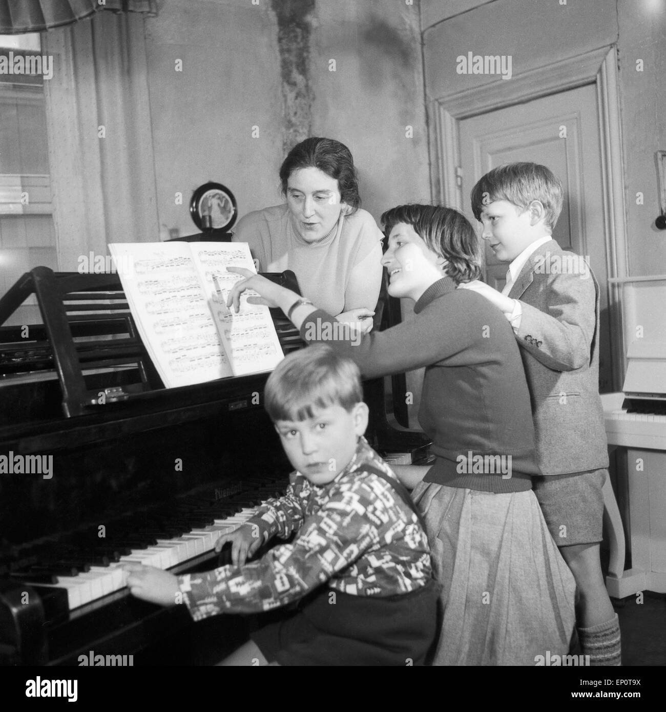 Kinder lernen bei ihrer Klavierlehrerin Klavier spielen, Amburgo 1956. I bambini imparano a suonare il piano con il loro maestro. Foto Stock