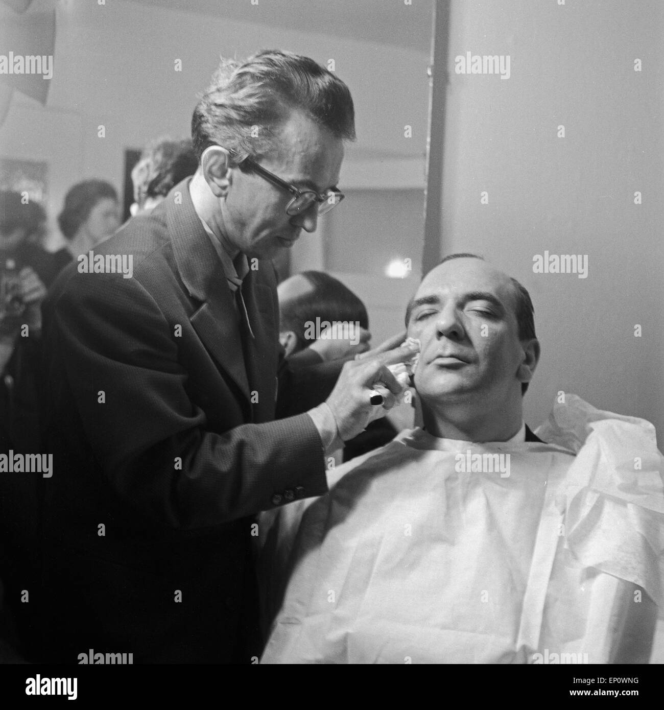 Einer der Moderatoren der Fernsehlotterie visualizza 'Die grosse possibilità' wird vom Maskenbilnder abgepudert, Deutschland 1950er Jahre. Foto Stock