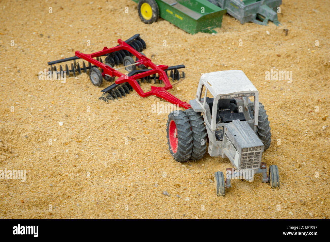 Trattore giocattolo e il disco aratro in sabbia vicino Federalsburg, Maryland, Stati Uniti d'America Foto Stock