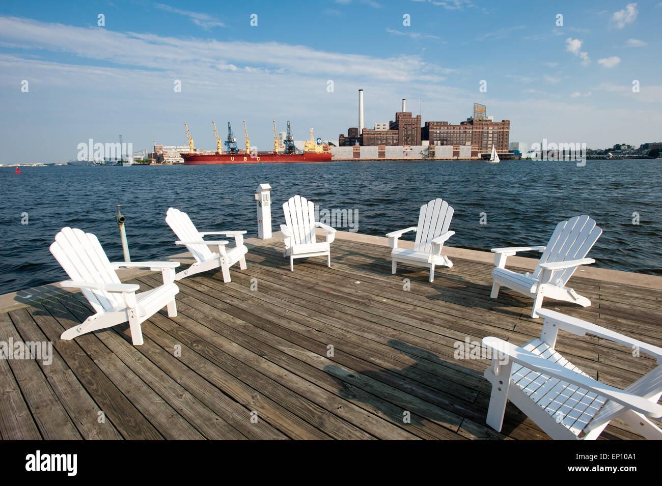 Bianco sedie in legno su un ponte dal porto di Baltimore, nei pressi di Fells Point, Maryland, Stati Uniti d'America Foto Stock