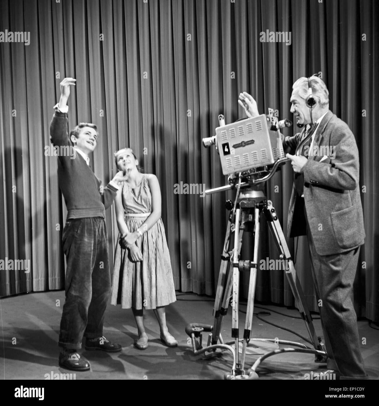 Ein junger Mann erklärt einem jungen Mädchen die Einwirkung des Lichteinfalls vor der Kamera, Deutschland 1950er Jahre. Un giovane Foto Stock