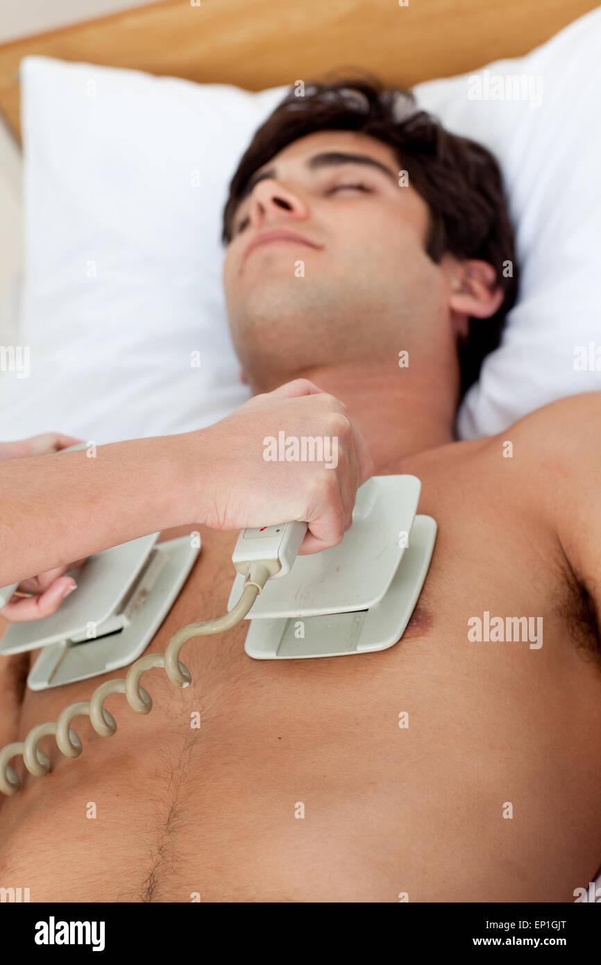 Un medico performimg una rianimazione cardiopolmonare con un defibrillatore Foto Stock