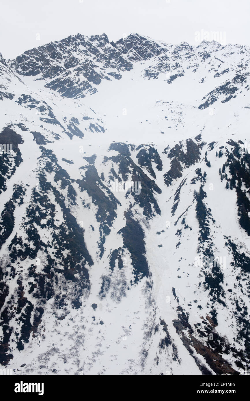 La fusione della neve sulle ripide pareti della Val Susasca, Engadina. Foto Stock