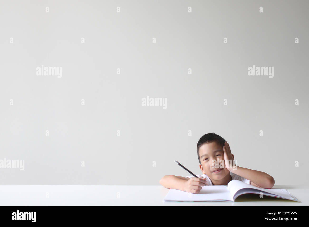 Ragazzo seduto ad un tavolo a studiare Foto Stock