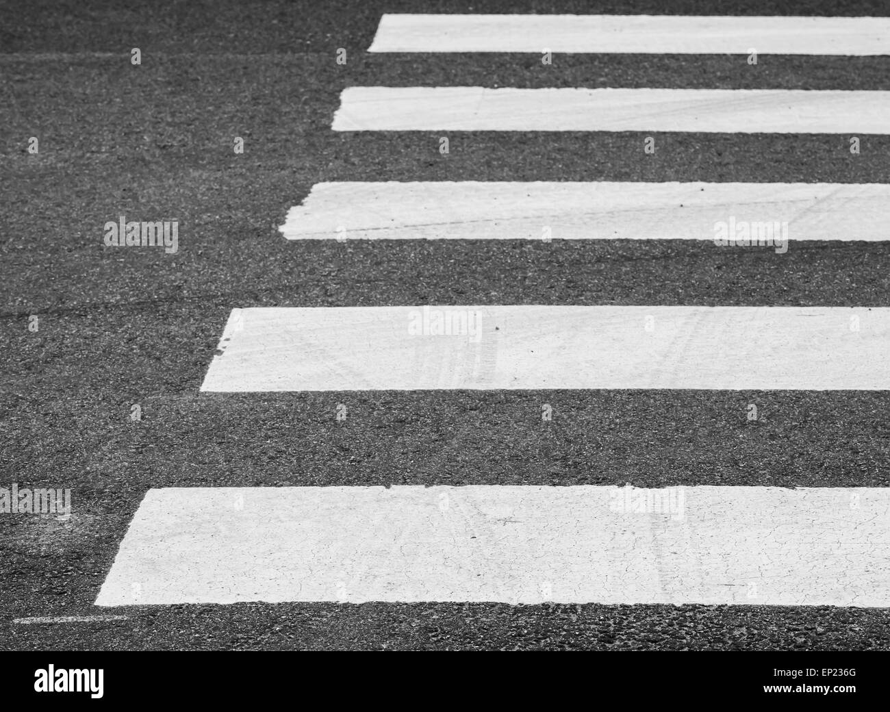 Grigio scuro strada asfaltata con attraversamento pedonale segnaletica, messa a fuoco selettiva con DOF poco profondo Foto Stock