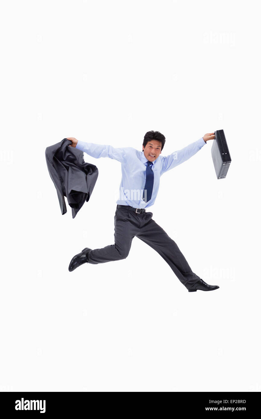 Allegro businessman jumping mantenendo la sua giacca e una valigetta Foto Stock