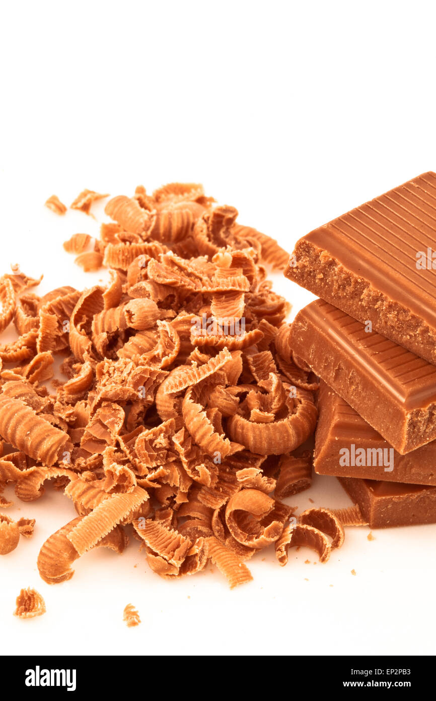 Molte scaglie di cioccolato accanto a un mucchio di cioccolato Foto Stock