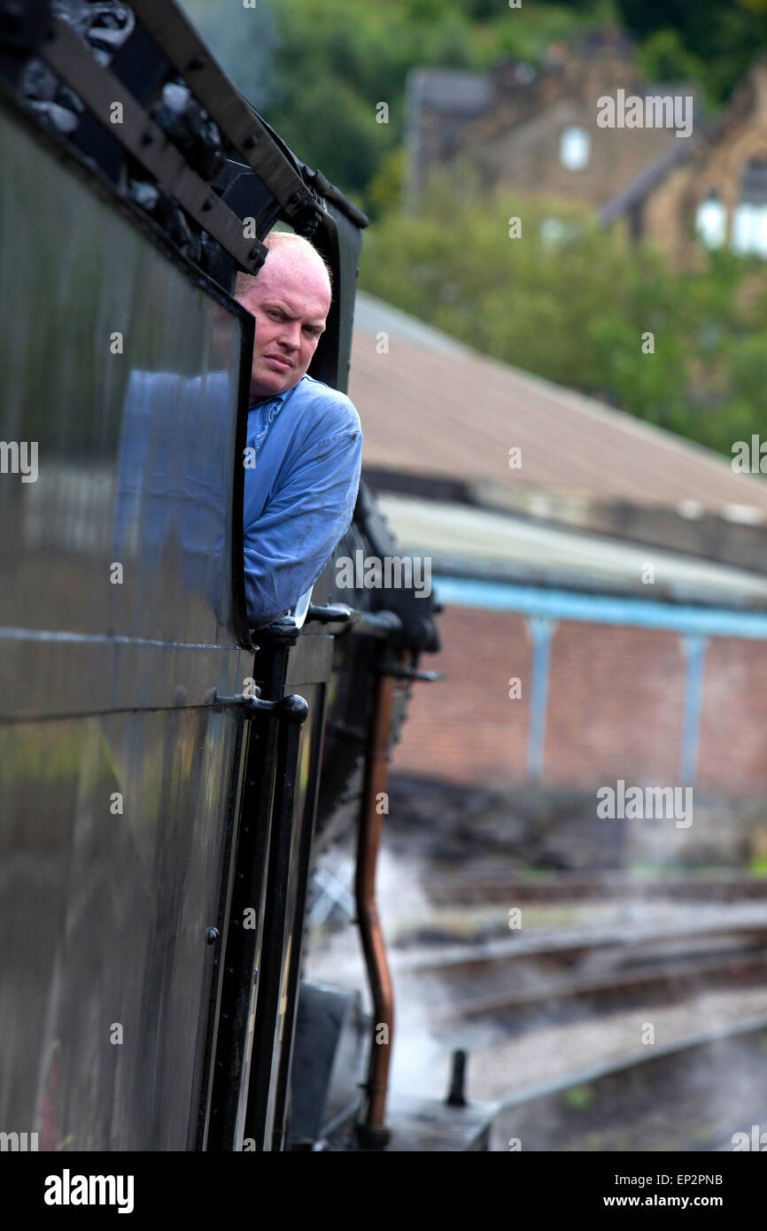 Driver del treno su una locomotiva a vapore a Keighley e Worth Valley Railway, nello Yorkshire, Gran Bretagna Foto Stock Driver del treno su una locomotiva a vapore a Keighley e Worth Valley Railway, nello Yorkshire, Gran Bretagna Foto Stock