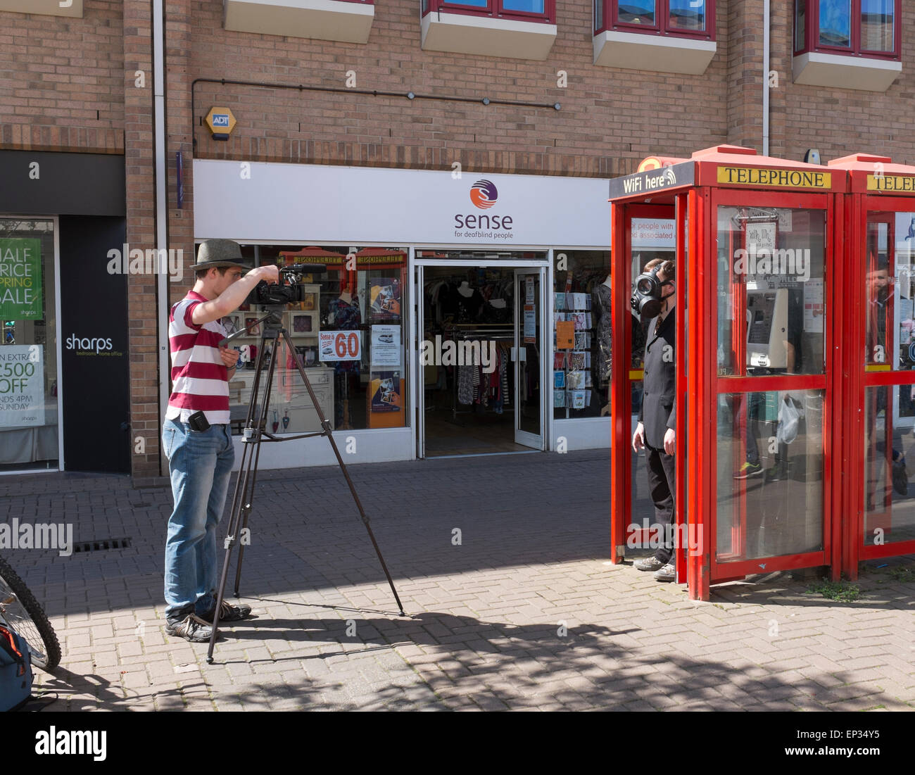 Realizzazione video di uomo in maschera a gas in cabina telefonica Burleigh Street Cambridge City Inghilterra Foto Stock