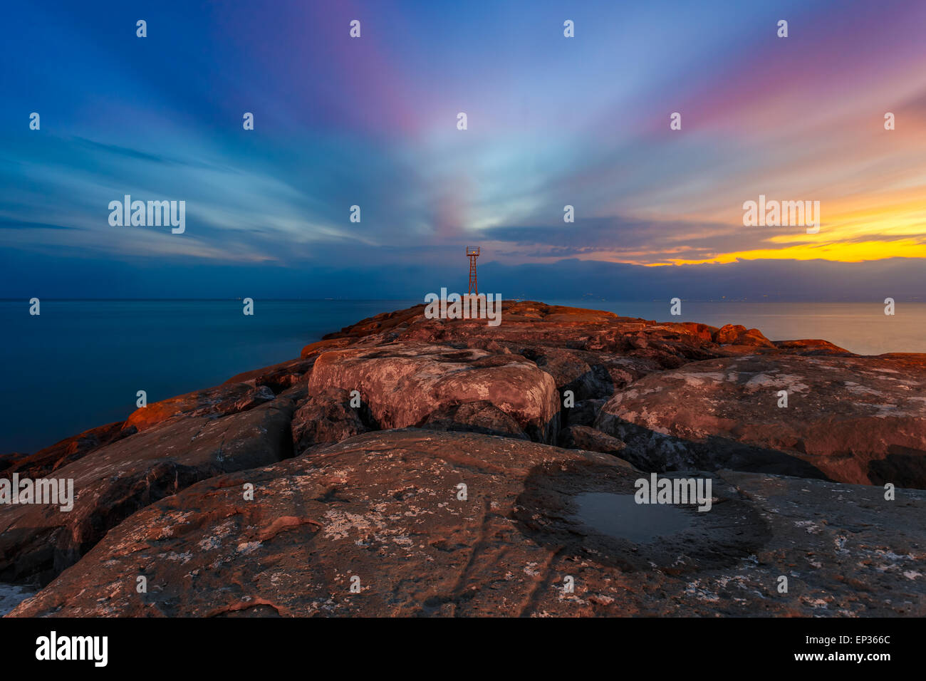 Faro di luce e di rocce interruttore d'onda vicino villaggio Acroyali, Messinia prefettura in Grecia contro un colorf Cielo di tramonto Foto Stock