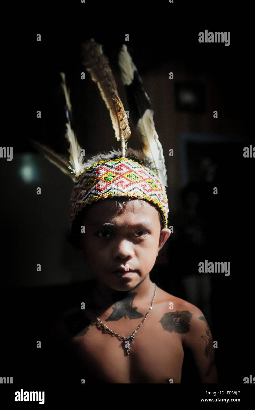 Ritratto di un bambino in abito tradizionale, con tatuaggi temporanei fatti con marcatore, in Sungai Utik, Kapuas Hulu, Kalimantan occidentale, Indonesia. Foto Stock