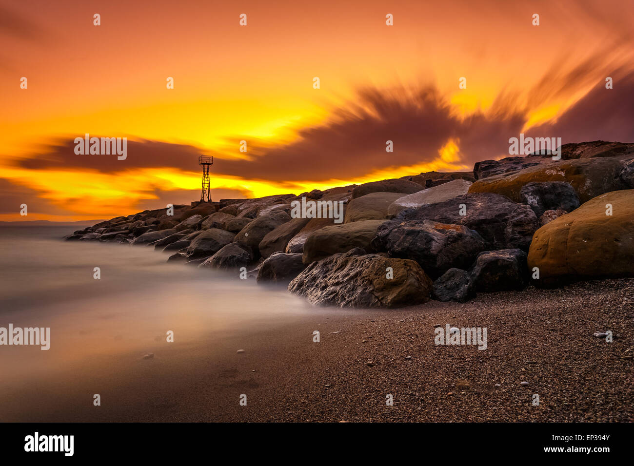 Faro di luce e di rocce interruttore d'onda vicino villaggio Acroyali, Messinia prefettura in Grecia contro un colorf Cielo di tramonto Foto Stock