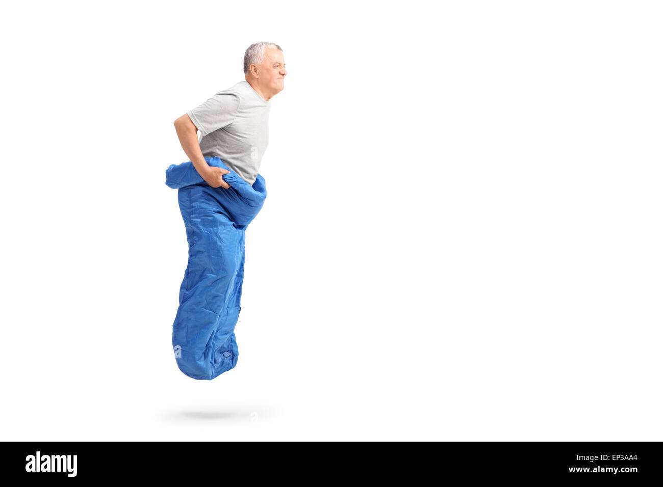 Senior uomo jumping in un sacco di colore blu e sorridente isolati su sfondo bianco Foto Stock