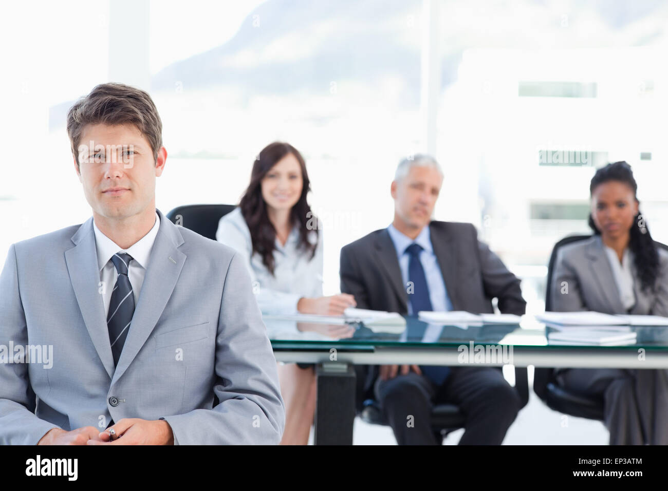 Caparra executive seduti davanti al suo compagno di squadra in una sala luminosa Foto Stock