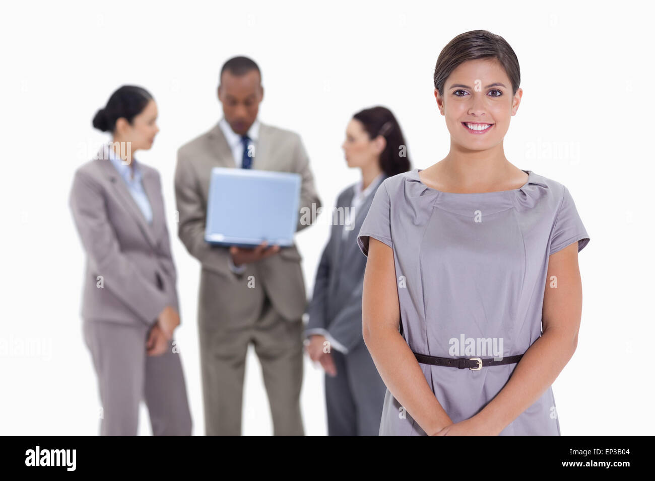 Donna sorridente con il team aziende in background con un laptop Foto Stock