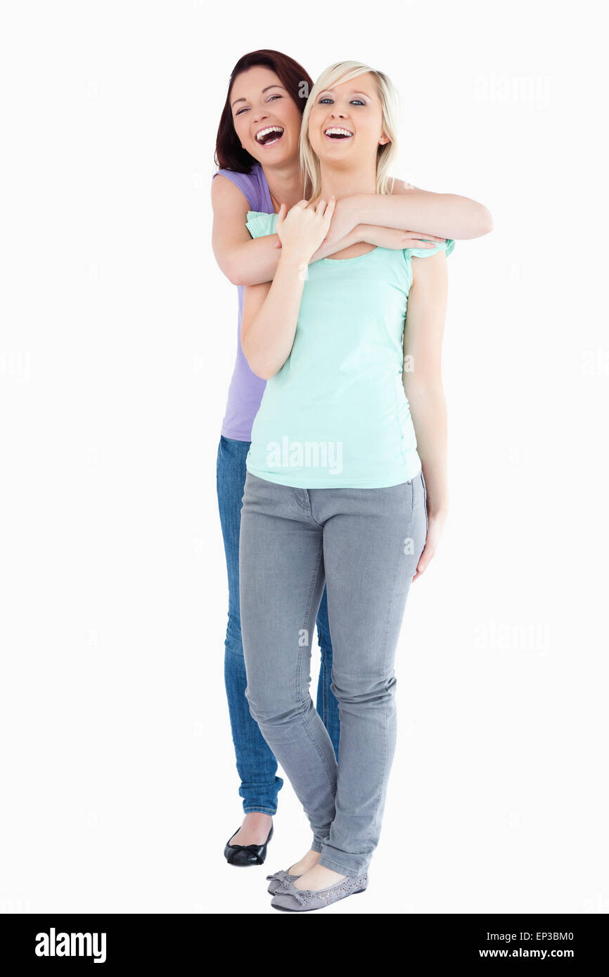 Donne che ridono avvolgente Foto Stock