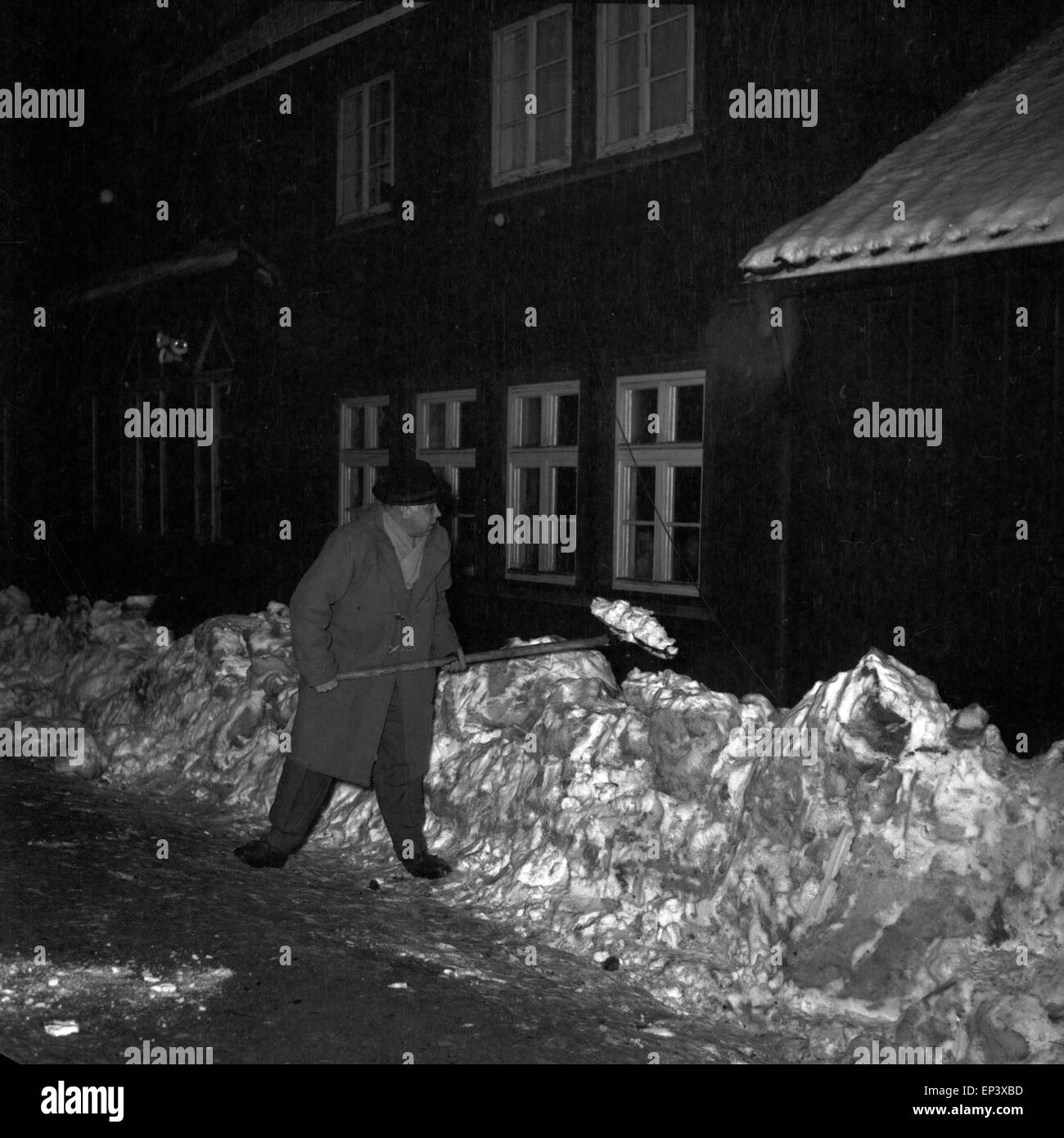 Ein Mann beim Schneeschippen vor dem Molkenhaus di Bad Harzburg, Deutschland 1950er Jahre. Un uomo che pulisce l'entrata di Molken Foto Stock