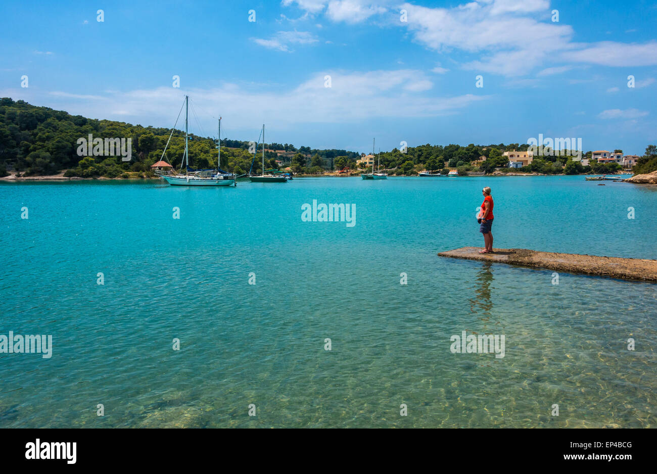 Porto Cheli Portocheli Harbour Porto, Grecia, con barche e figura solitaria, blu cielo, mare blu Foto Stock