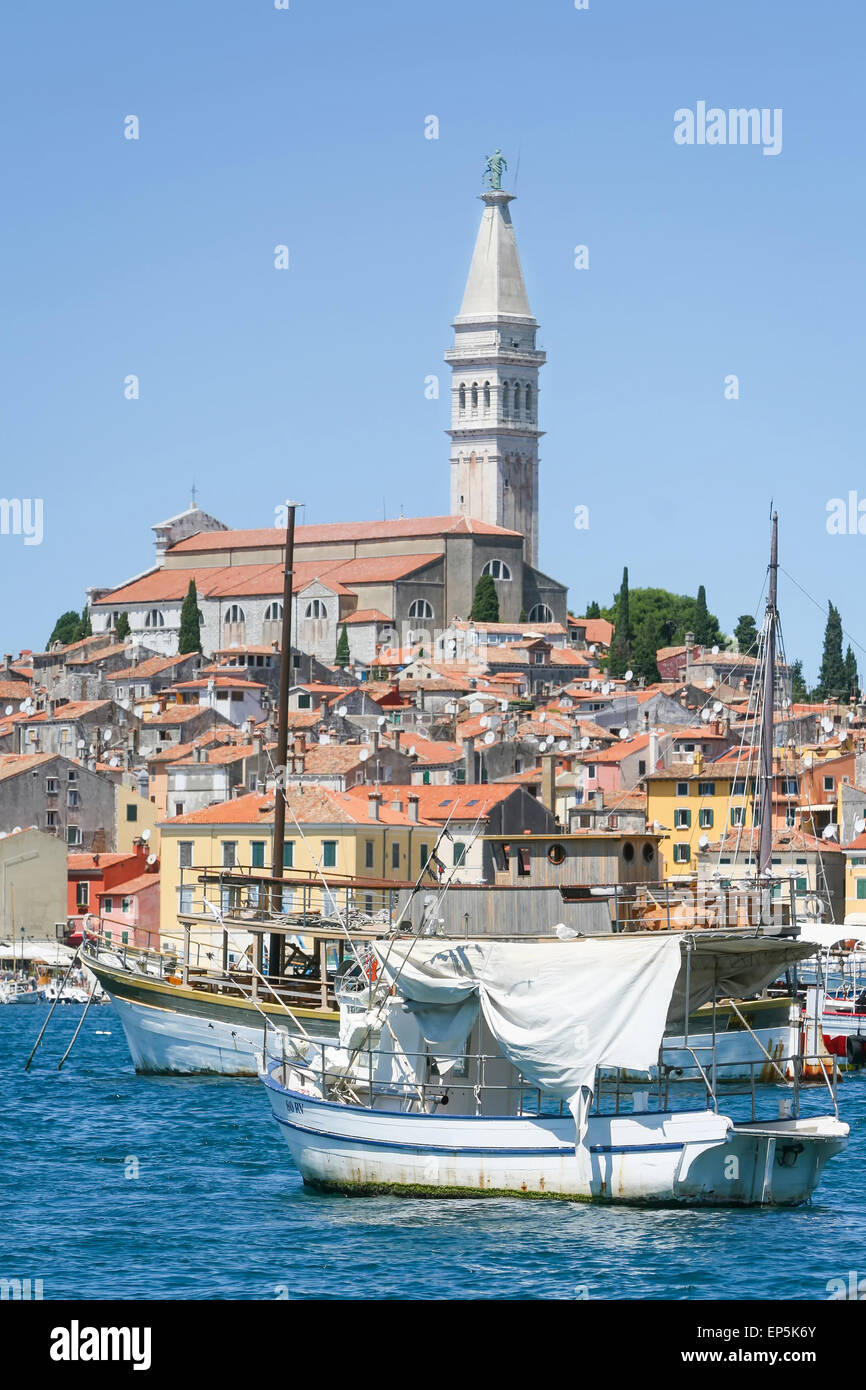 Barche ancorate nella marina e il nucleo storico della città con la Santa Eufemia chiesa in background di Rovigno Croazia. Foto Stock