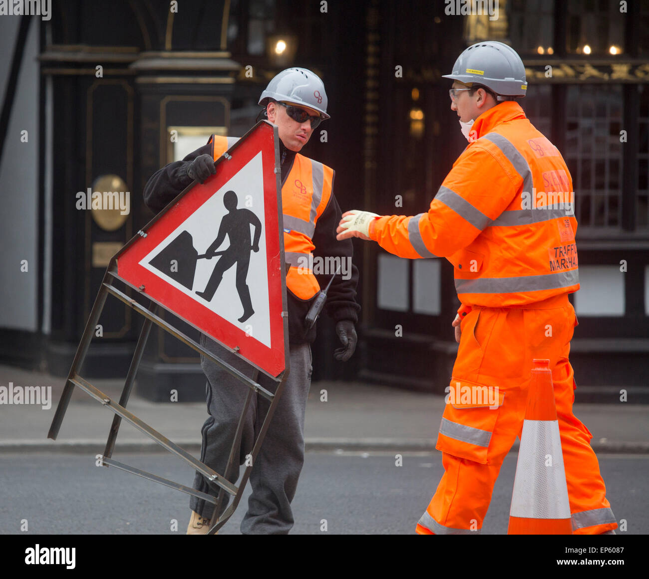 Uomo che porta roadworks segno workman elmetto arancione Foto Stock