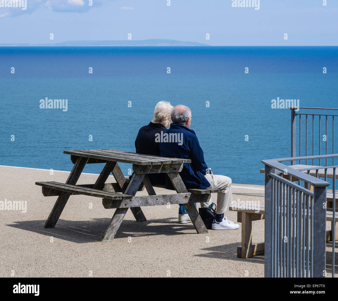 Coppia Matura seduta che guarda al mare in una bella giornata, dal castello di Durlston, Dorset, England, Regno Unito Foto Stock