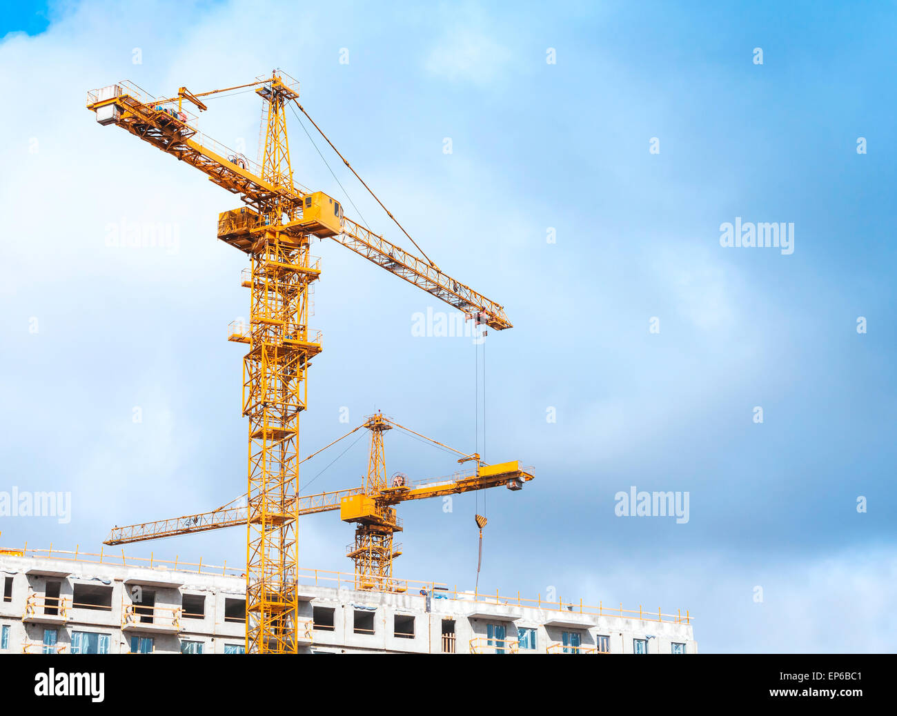 Gru gialle Lavori in calcestruzzo moderne abitazioni massiccia in costruzione Foto Stock
