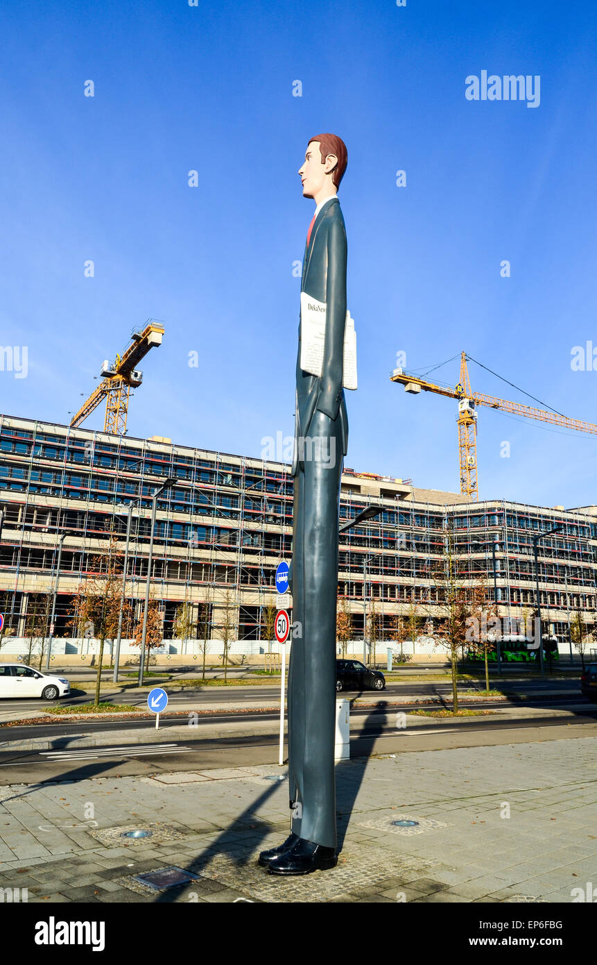 Statua di 'l'alto banchiere' in Kirchberg, Lussemburgo città e gru edili in background Foto Stock