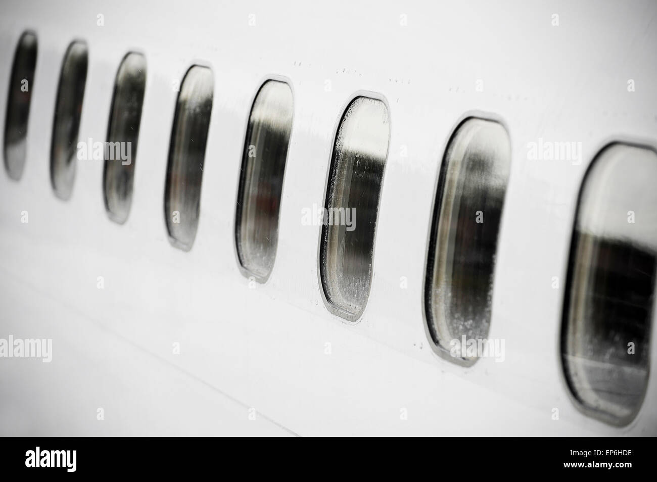 Foto vignettato di oblò di aereo in una fila con gocce di pioggia su di essi Foto Stock
