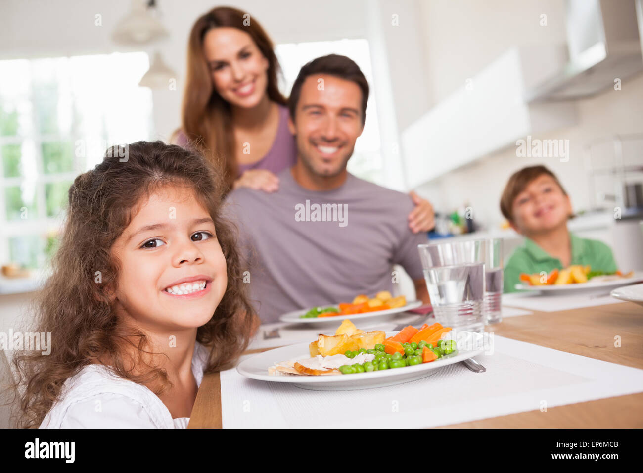 Famiglia sorridente con la videocamera al tavolo per la cena Foto Stock